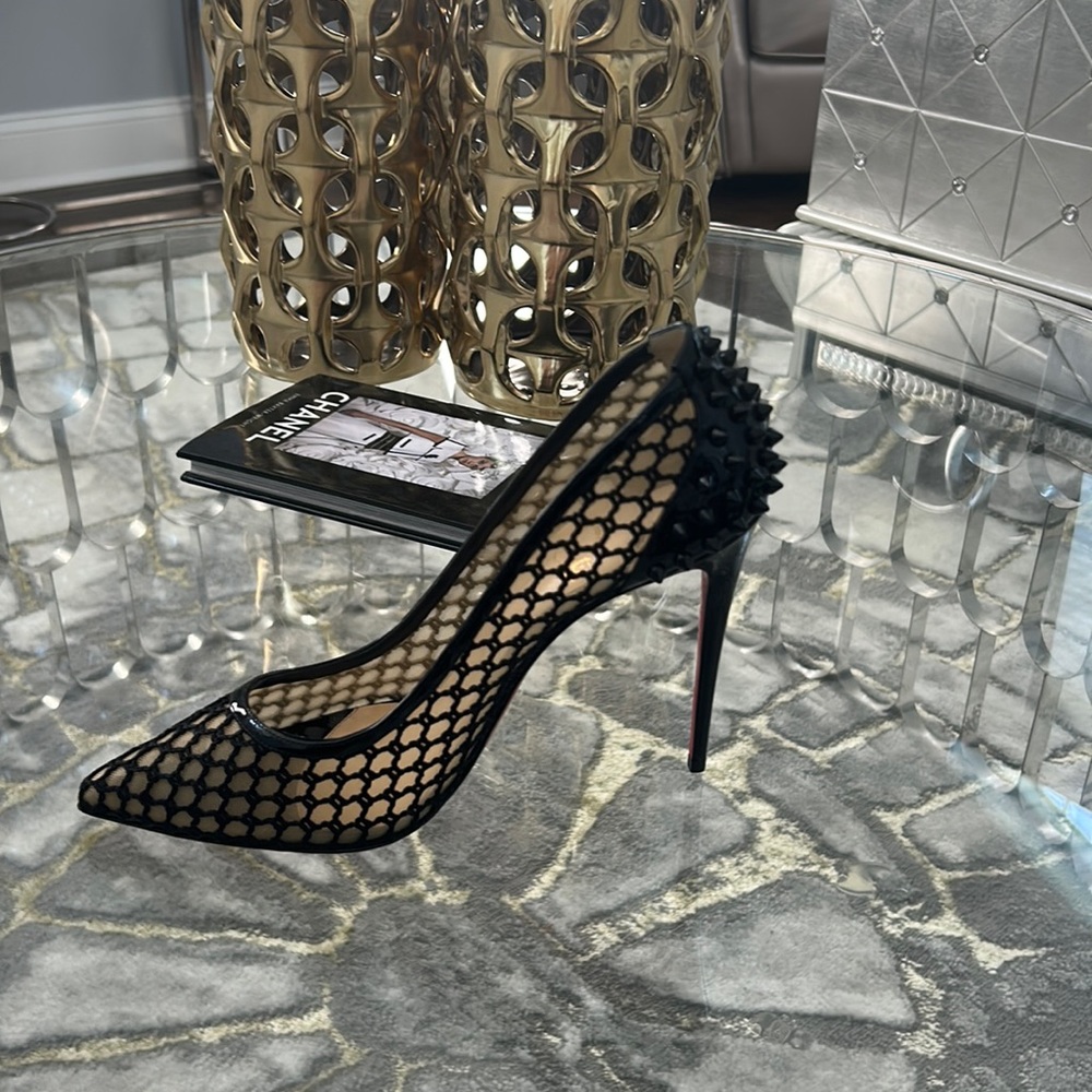 Black mesh pointy toe high heel pump with spikes on heel.